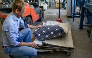 Ze solárních panelů nejdříve pracovníci linky odstraní hliníkové rámy a kabeláž, jak ukazuje Vojtěch Musil. Foto: Karolína Chlumecká, Ekonews