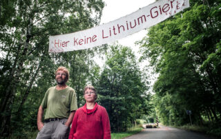 Jens a Britta Weberovi nad příjezdovou silnici uprostřed místních lesů v údolí Bärenstein vyvěsili transparent vyrobený z prostěradel s heslem Stop honbě za lithiem! Foto: Kateřina Hefler, Ekonews
