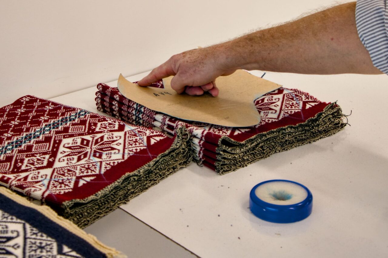 Jiří Pertl ukazuje, jak se úplet řeže podle vzoru. Foto: Karolína Chlumecká, Ekonews