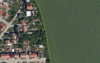 Žlutě je vyznačen obecní pozemek kolem obytné zástavby. Zelená čára je hranice pšeničného pole, na kterém jsou vidět vyježděné koleje od postřikovače. Na obecním pozemku je vidět vzrostlá dřevitá vegetace, která odděluje zahrady od pole. Přesto lze v některých úsecích toto nárazníkové pásmo ještě rozšířit. Zdroj: LPIS, Živá půda